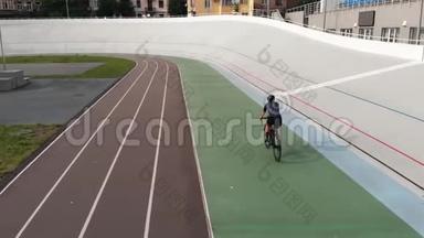 骑公路自行车的女自行车手正在赛车场训练。自行车跑道上骑自行车的运动女孩的特写镜头。在赛车场训练